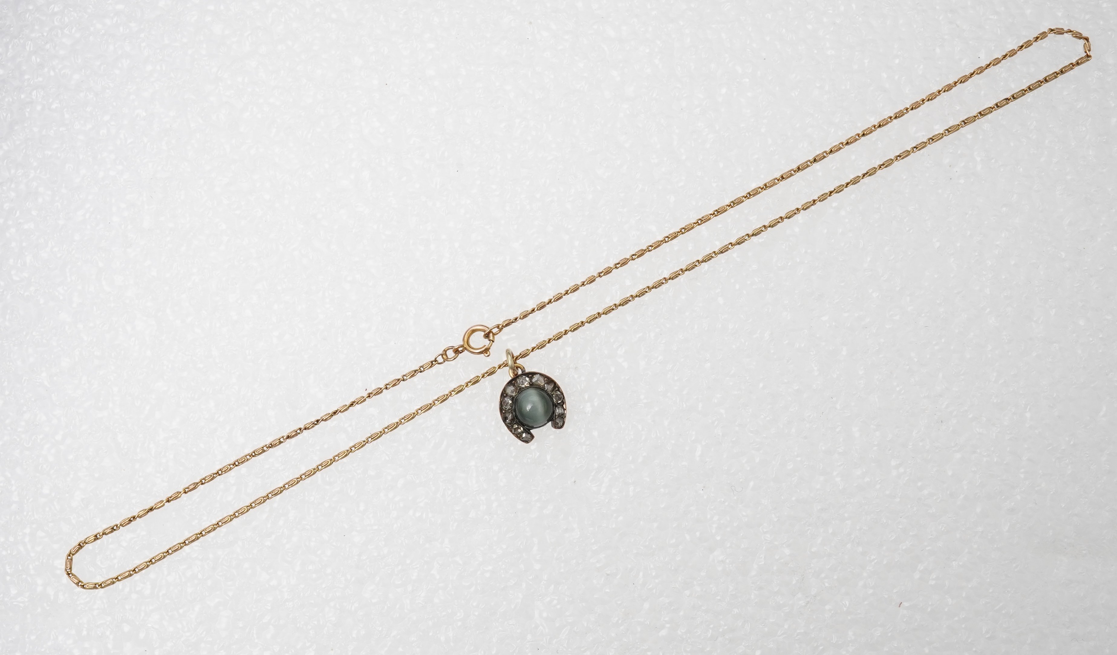 A yellow metal, cat's eye quartz and rose cut diamond cluster set horseshoe pendent, 11mm, together with a 9ct gold chain, 41cm, gross weight 5 grams.